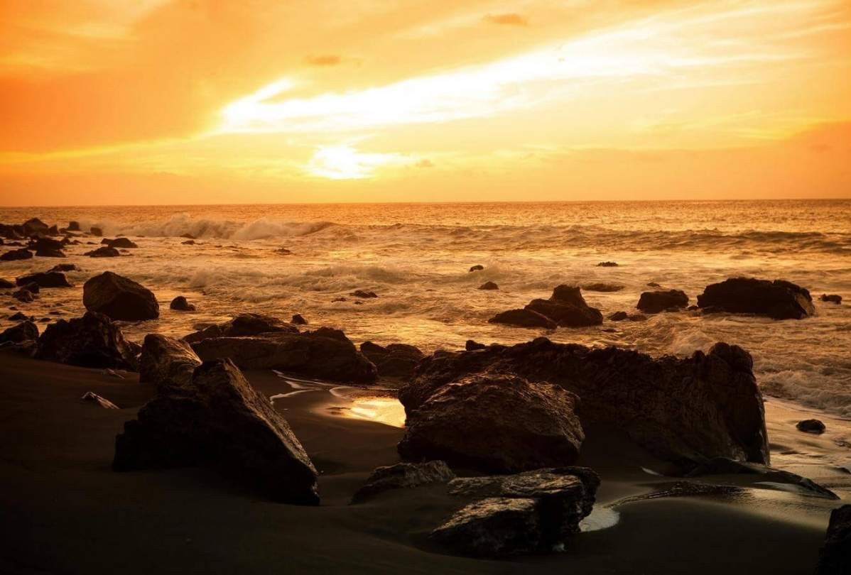 Puesta de sol en Playa del Inglés, La Gomera, con el océano Atlántico y el cielo tintados de color naranja
