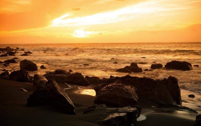 Sonnenuntergang am Playa del Inglés auf La Gomera, mit dem Atlantik und dem orange gefärbten Himmel